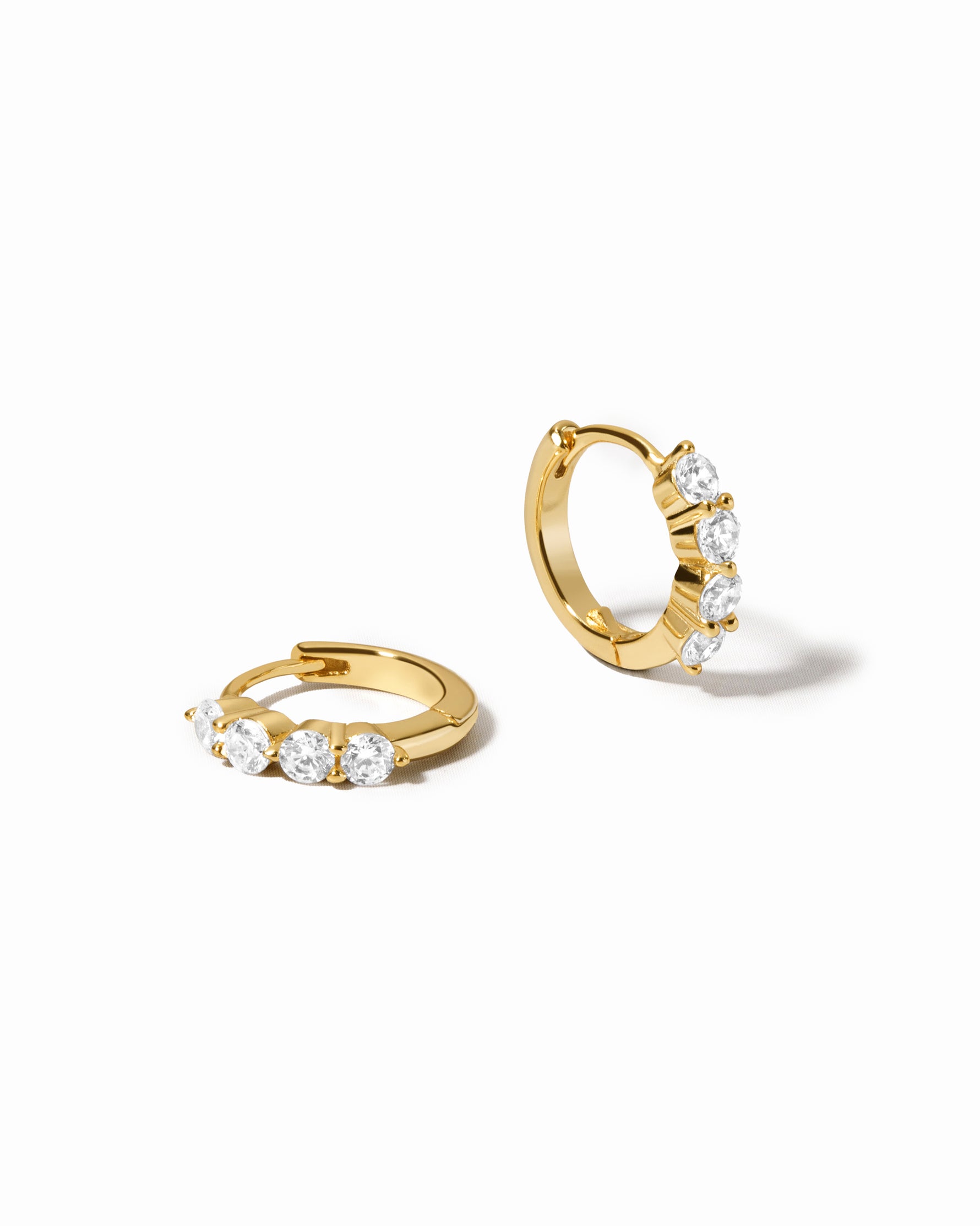 diamond huggie hoop earrings in 9mm in gold on a white background