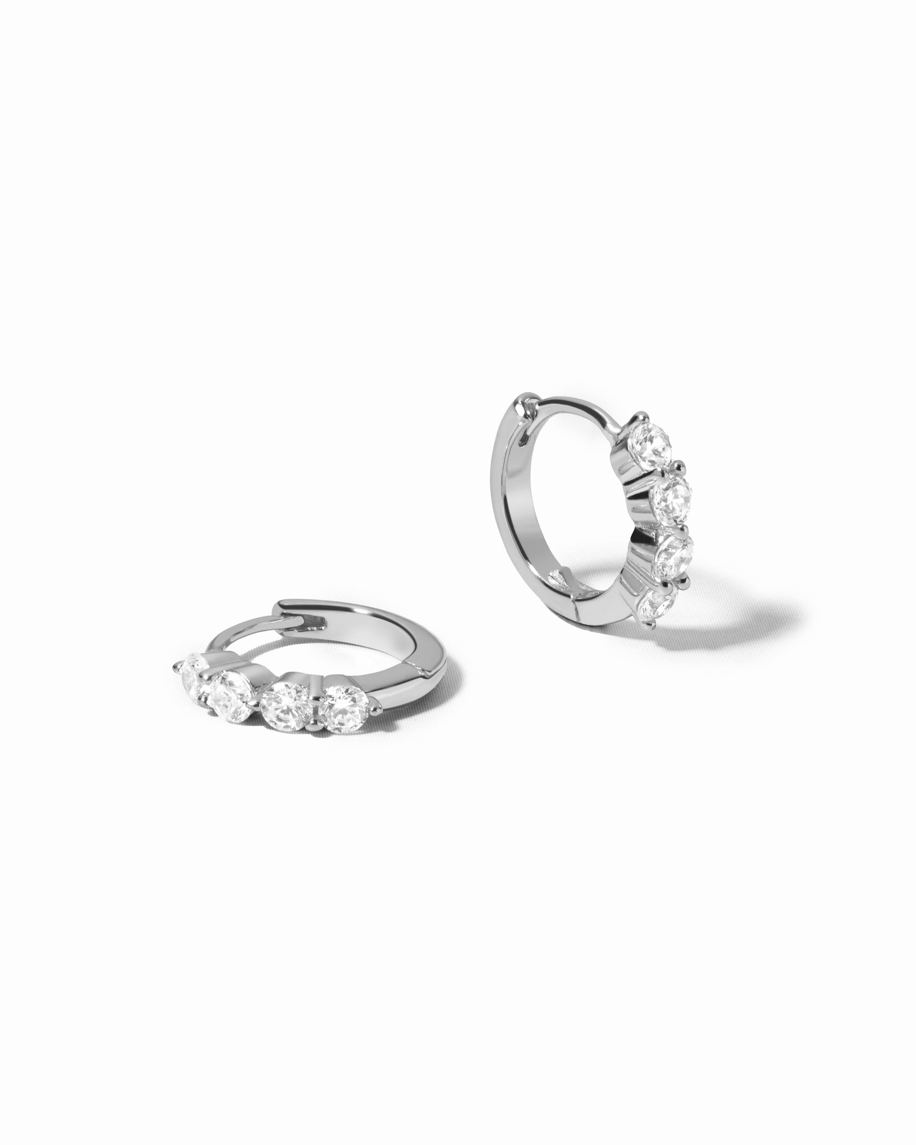 diamond huggie hoop earrings in 9mm in sterling silver on a white background