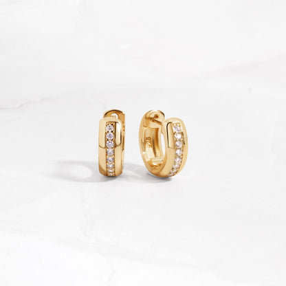 a pair of dainty gold hoop earrings featuring pave stones in the center