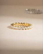 Slanted white cubic zirconia baguette ring in gold, showing the ring's design and sparkling stones on a white background.