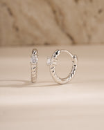 Sterling silver diamond spiral huggie earrings by Sami Jewels featuring sparkling diamond accents and a sleek spiral design.