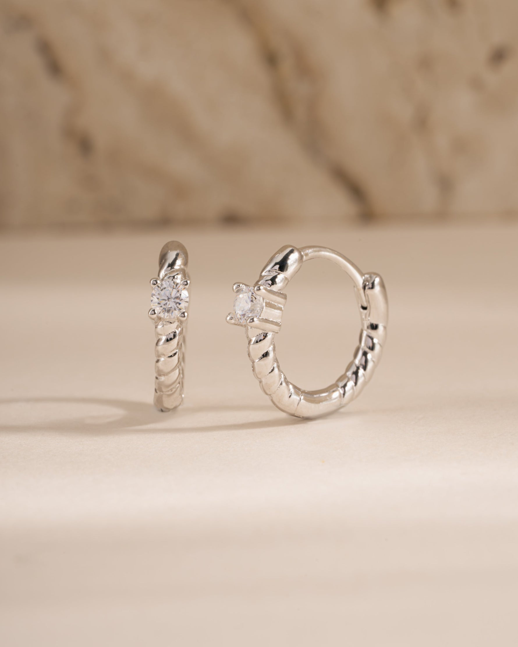 Sterling silver diamond spiral huggie earrings by Sami Jewels featuring sparkling diamond accents and a sleek spiral design.