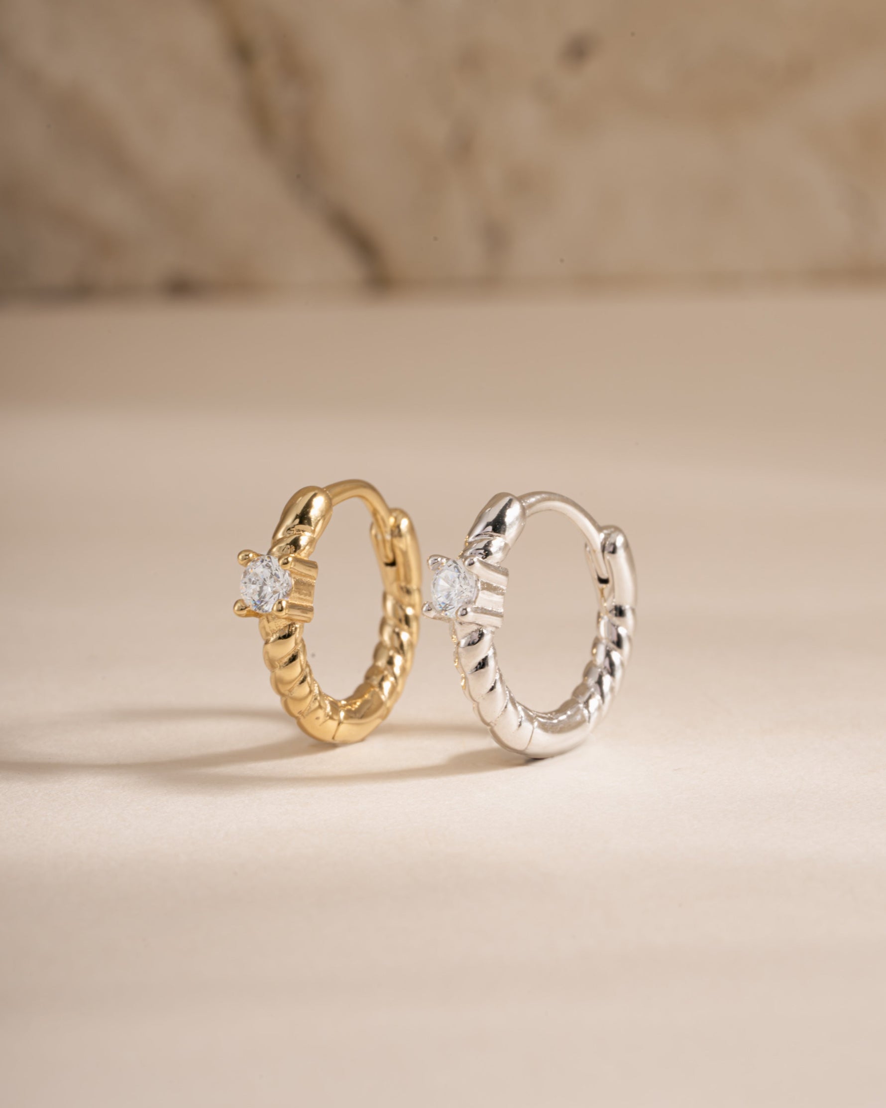 Diamond spiral huggie earrings by Sami Jewels featuring gold and sterling silver with sparkling diamond accents.