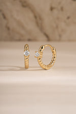Gold Diamond Spiral Huggie Hoop Earrings by Sami Jewels featuring sparkling diamonds and a stylish spiral design.