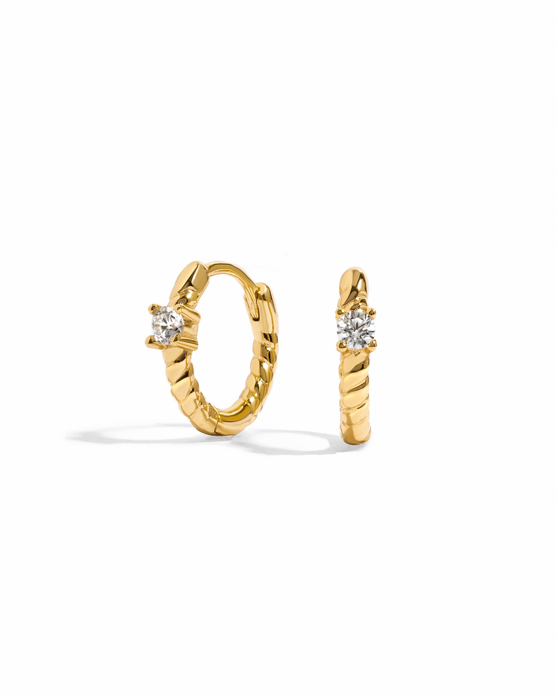 Gold diamond spiral huggie earrings by Sami Jewels, featuring a sleek circular design with sparkling diamonds on a white background.