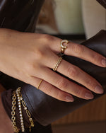 Gold diamond stacking ring by Sami Jewels worn on model's finger, showcasing elegant jewelry design and sparkling gemstones.