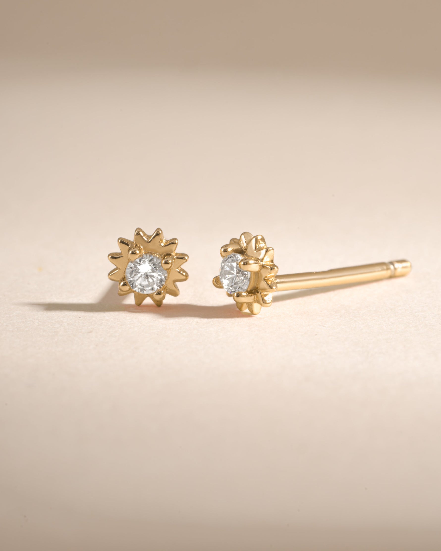 Sami Jewels CZ Tiny Sunburst Stud Earrings with diamond accents, showcasing a radiant sunburst design in a close-up image.