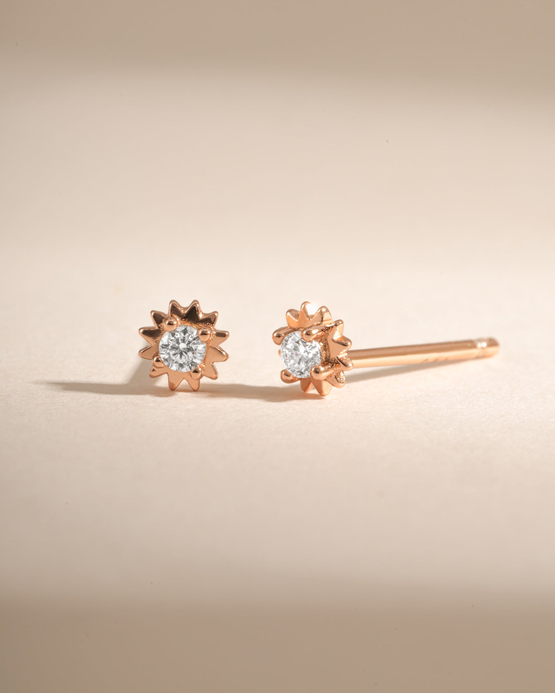 Rose gold CZ Tiny Sunburst Stud Earrings by Sami Jewels featuring sparkling diamond-like sunburst design.