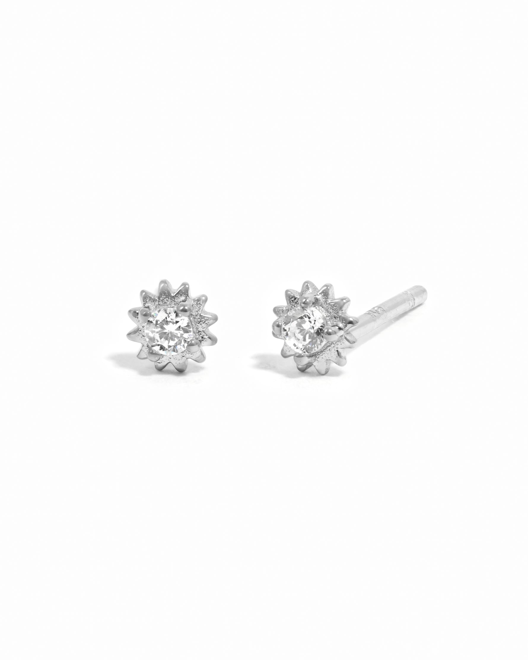 Sterling silver CZ Tiny Sunburst Stud Earrings by Sami Jewels displayed on a white background.
