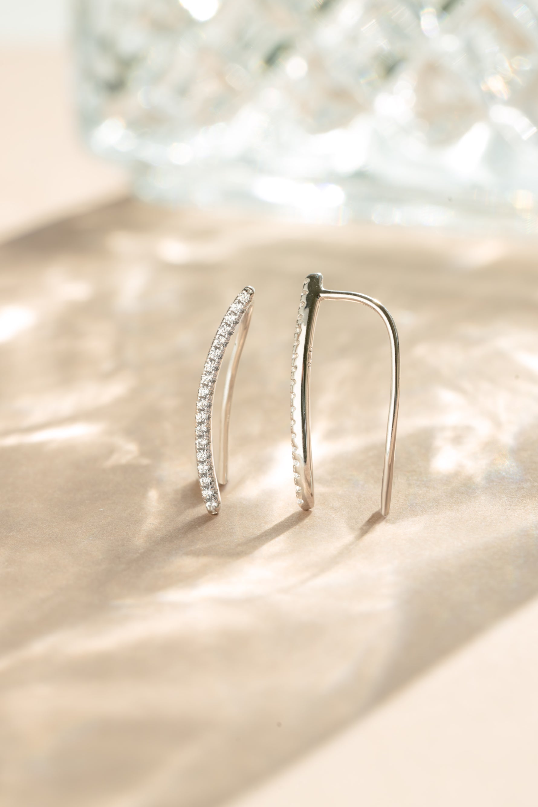 Sterling silver studded ear climber earrings by Sami Jewels with diamond accents on a neutral background.