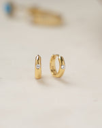 Gold Dome Diamond Huggie Earrings by Sami Jewels, featuring small sparkling diamonds and a rounded dome design.