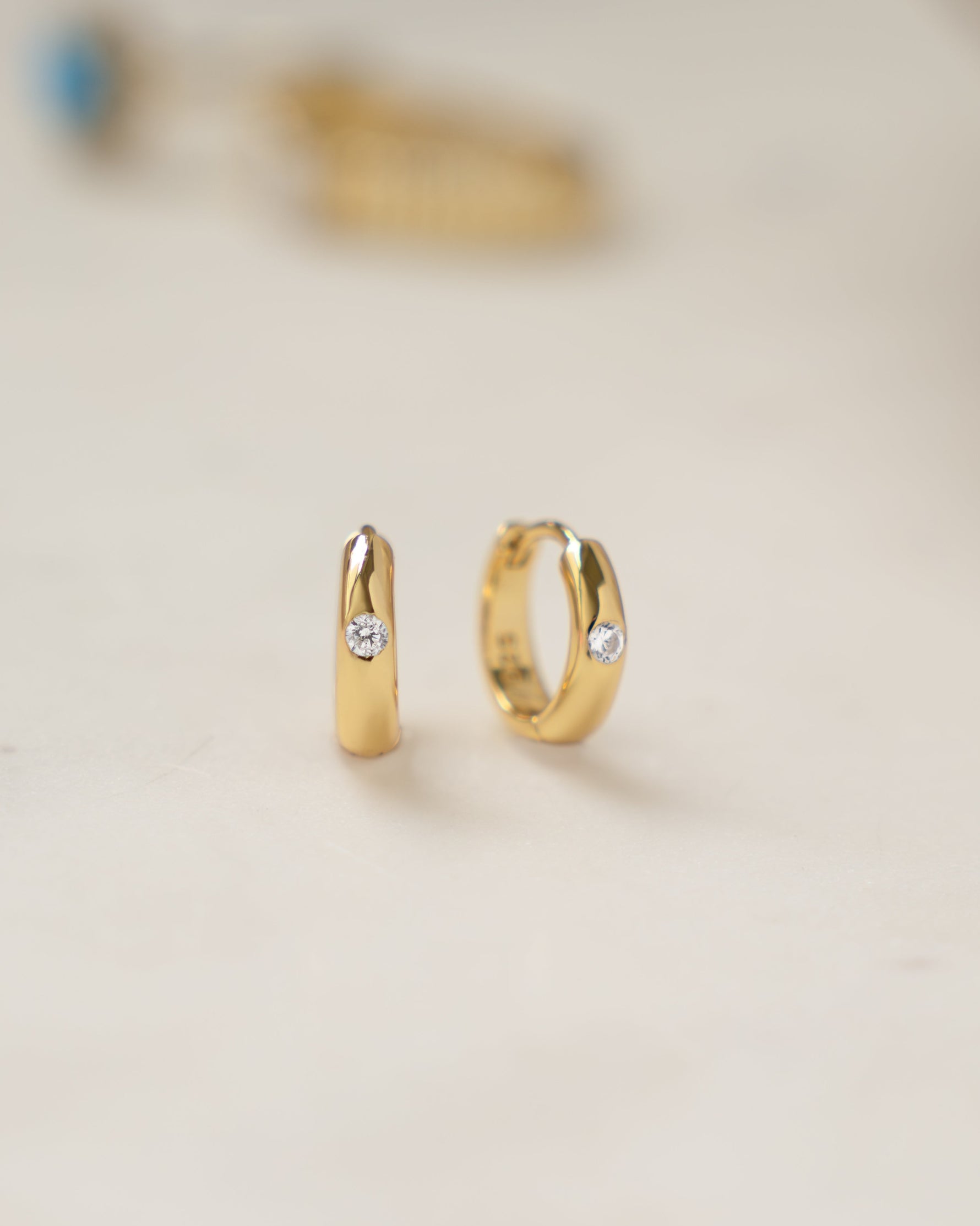 Gold Dome Diamond Huggie Earrings by Sami Jewels, featuring small sparkling diamonds and a rounded dome design.