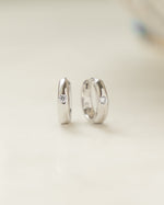 Sterling silver Dome Diamond Huggies earrings featuring small sparkling diamonds and a sleek, rounded design by Sami Jewels.