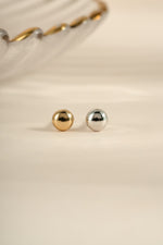 Gold and sterling silver dot stud earrings by Sami Jewels featuring sleek, minimalist design with small round studs.