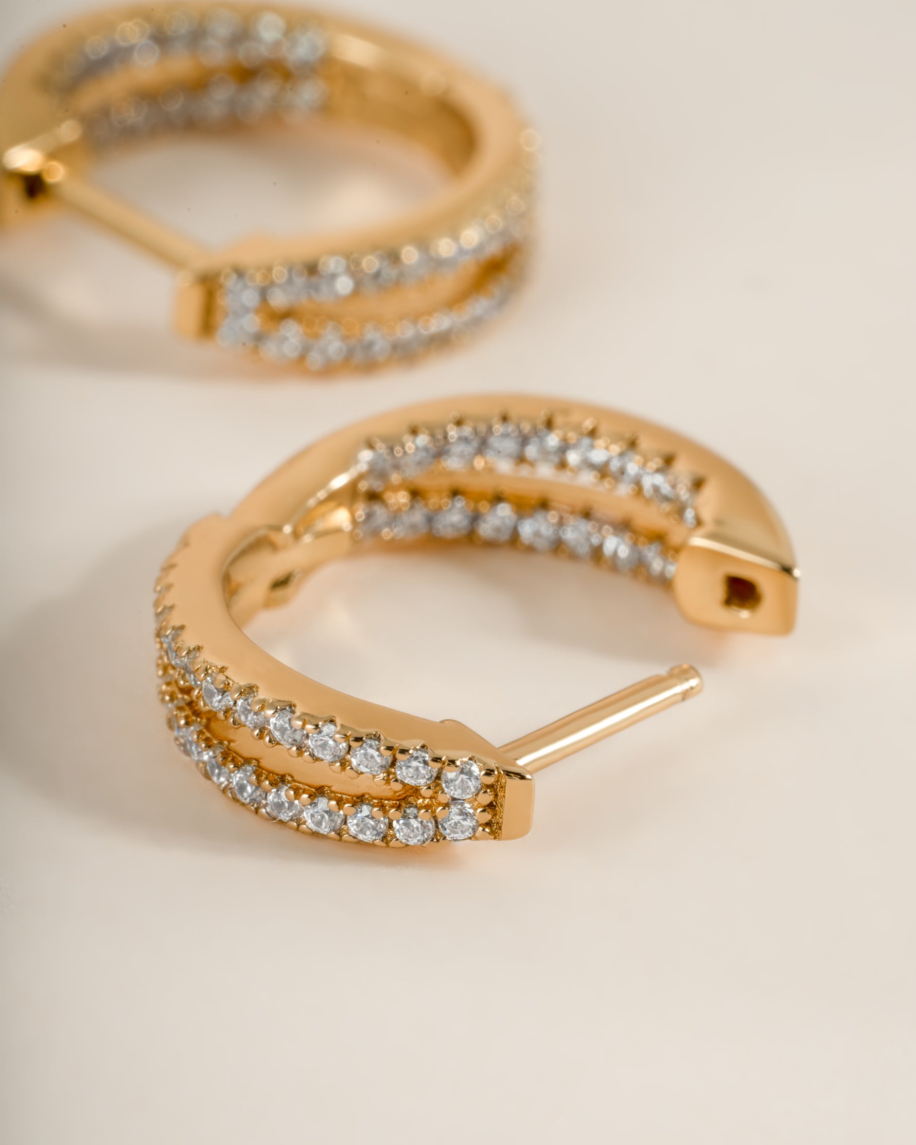 Close-up of gold double hoop earrings from Sami Jewels, showcasing their stylish and shiny design.