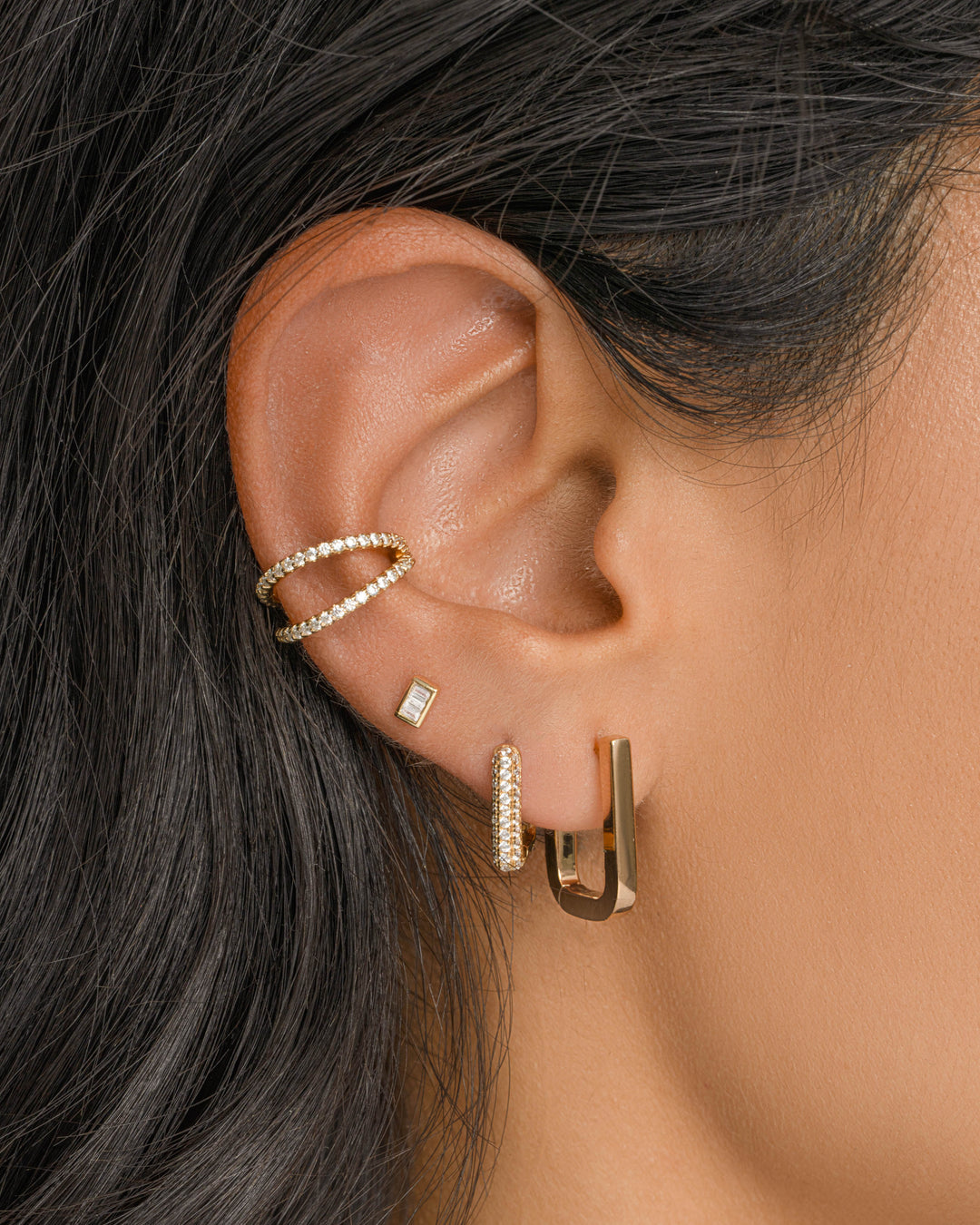 Gold Marcella Double Row Ear Cuff earrings with diamond accents worn on a model’s ear. Sami Jewels jewelry.