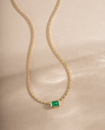 Gold necklace with emerald baguette bezel setting, statement jewelry piece from Samijewels-527 featuring vibrant green gemstones.