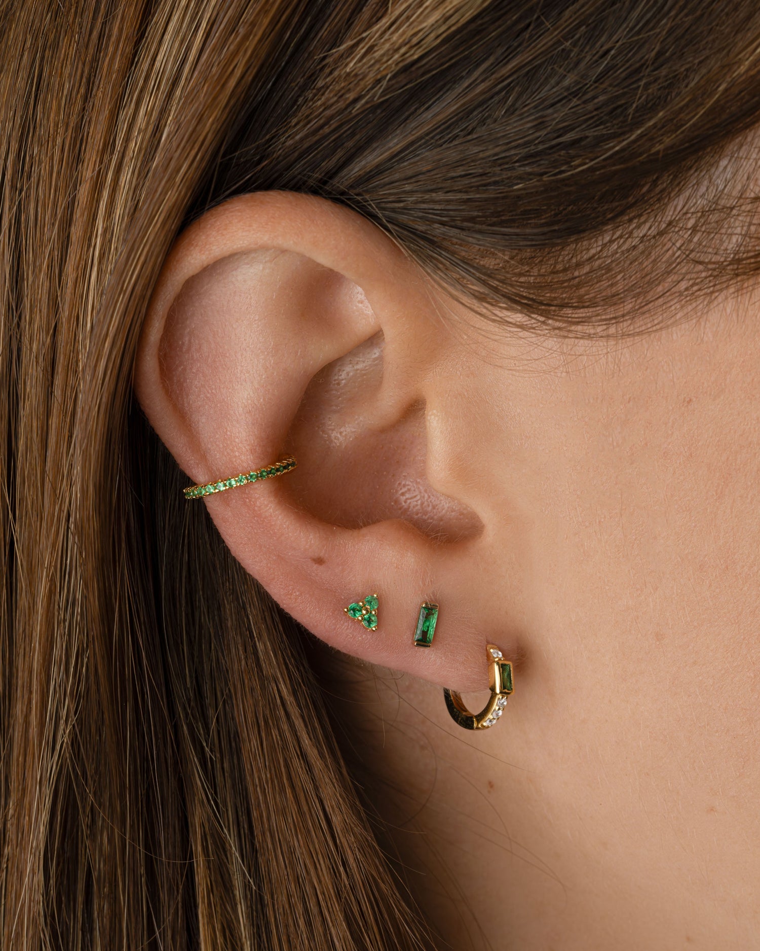 Gold Sami Jewels emerald baguette huggie earrings featuring sleek, rectangular emerald gemstones and classic hoop design.