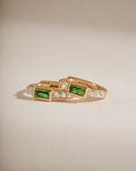 Gold emerald baguette huggie earrings with side view, showcasing sleek design and sparkling green gemstones from Sami Jewels.