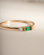 Close-up of Sami Jewels emerald baguette ring featuring a gold band and a rectangular emerald gemstone.