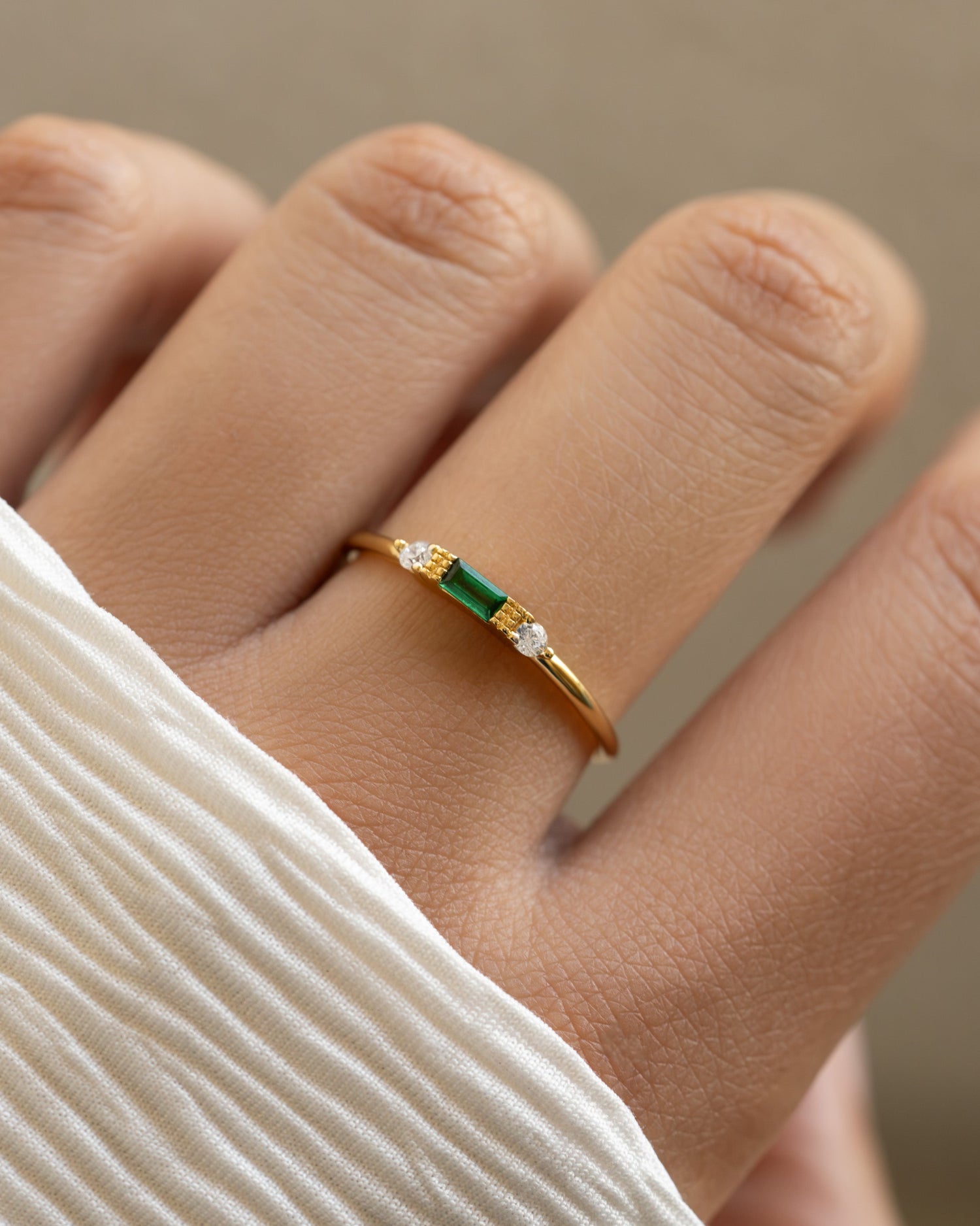 Gold emerald baguette ring by Sami Jewels featuring a rectangular emerald gemstone set in a sleek gold band.