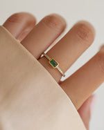 emerald baguette ring with pave band in gold on models hand 