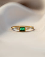 emerald baguette ring with pave band in gold closeup