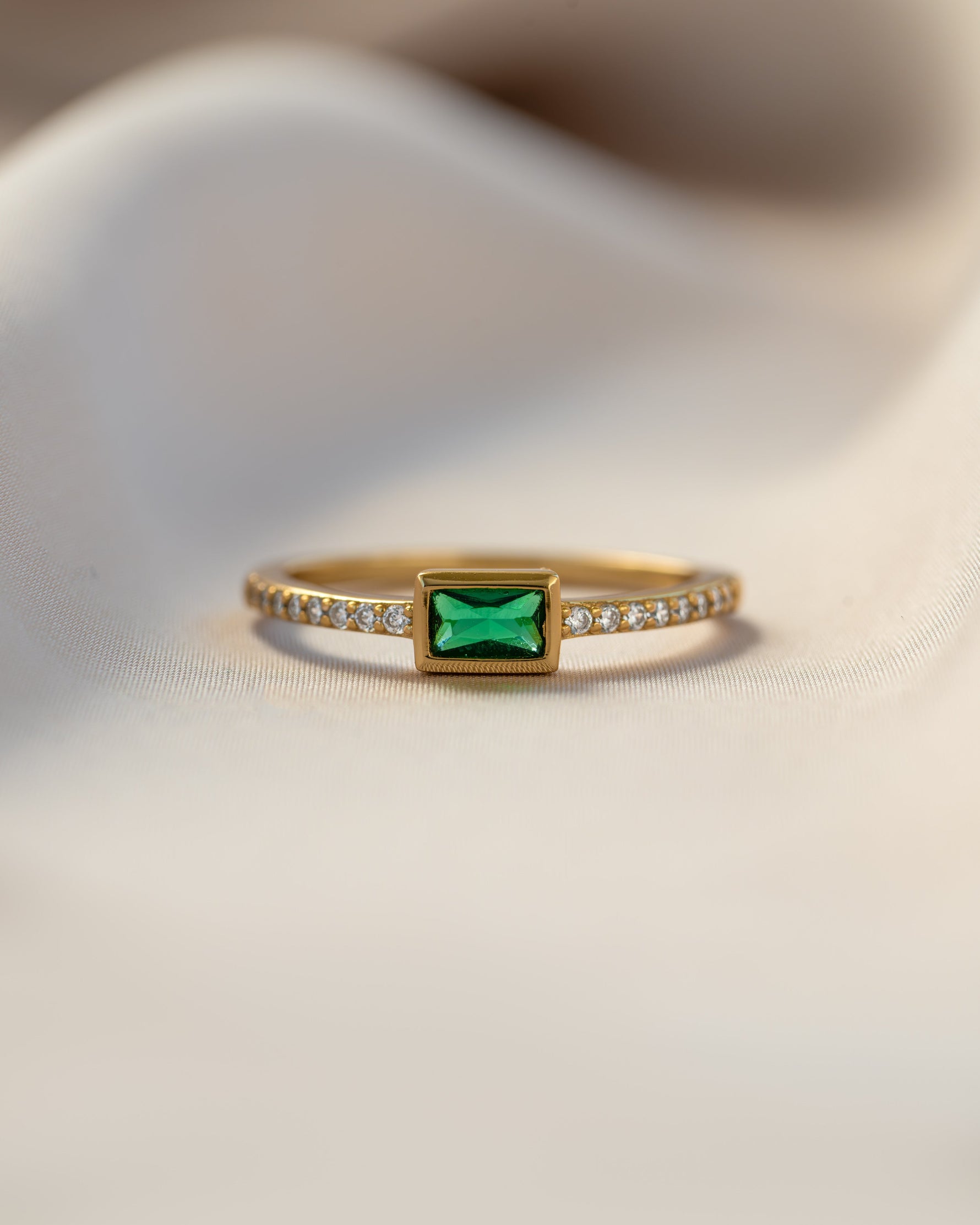 emerald baguette ring with pave band in gold closeup