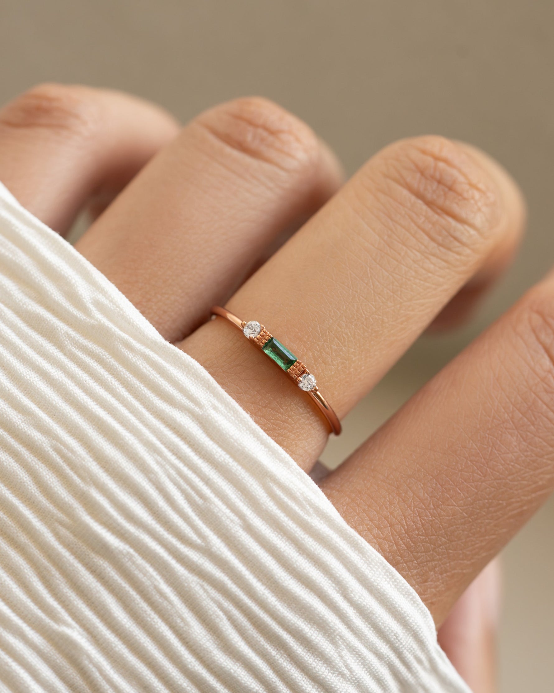 Sami Jewels emerald baguette ring with rose gold band, featuring a rectangular emerald gemstone and elegant design.