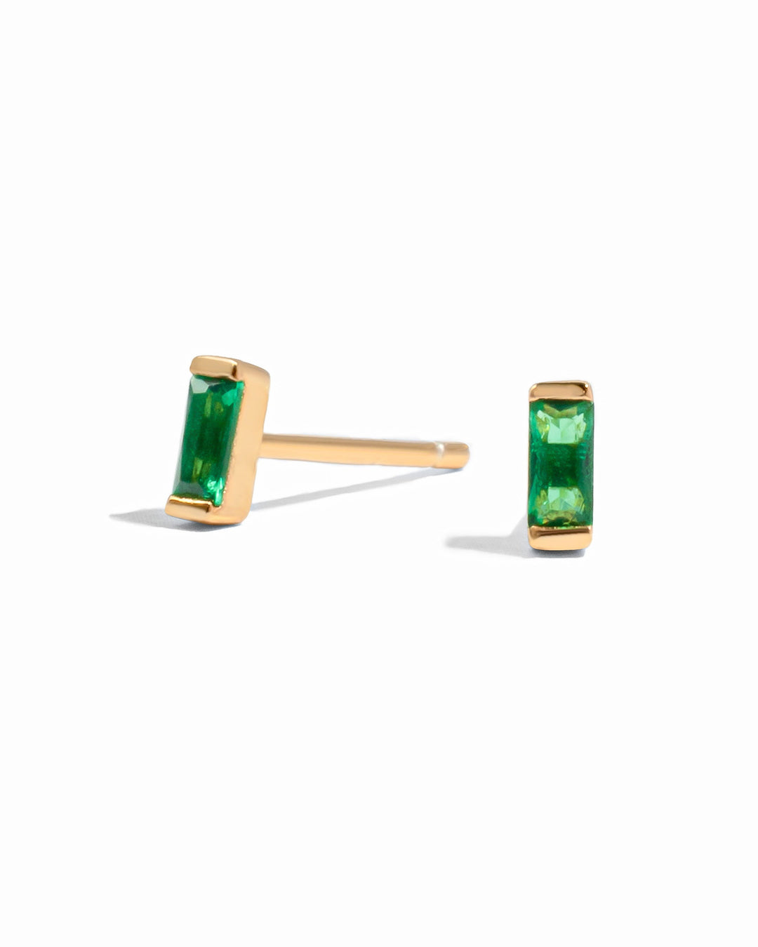 Gold emerald baguette stud earrings by Sami Jewels displayed on a white background.