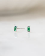 emerald baguette stud earrings in sterling silver with a blurred background
