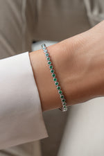 Model wearing the gold emerald tennis bracelet with a casual outfit