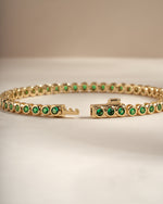 Detail of round green bezel settings on emerald tennis bracelet, view 3