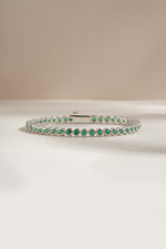 Detail of round green bezel settings on emerald tennis bracelet, view 5