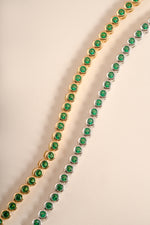 Detail of round green bezel settings on emerald tennis bracelet, view 6