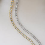 Close-up of Sami Jewels emerald-cut bezel tennis bracelet in silver and gold, showcasing elegant design and sparkling gemstones.