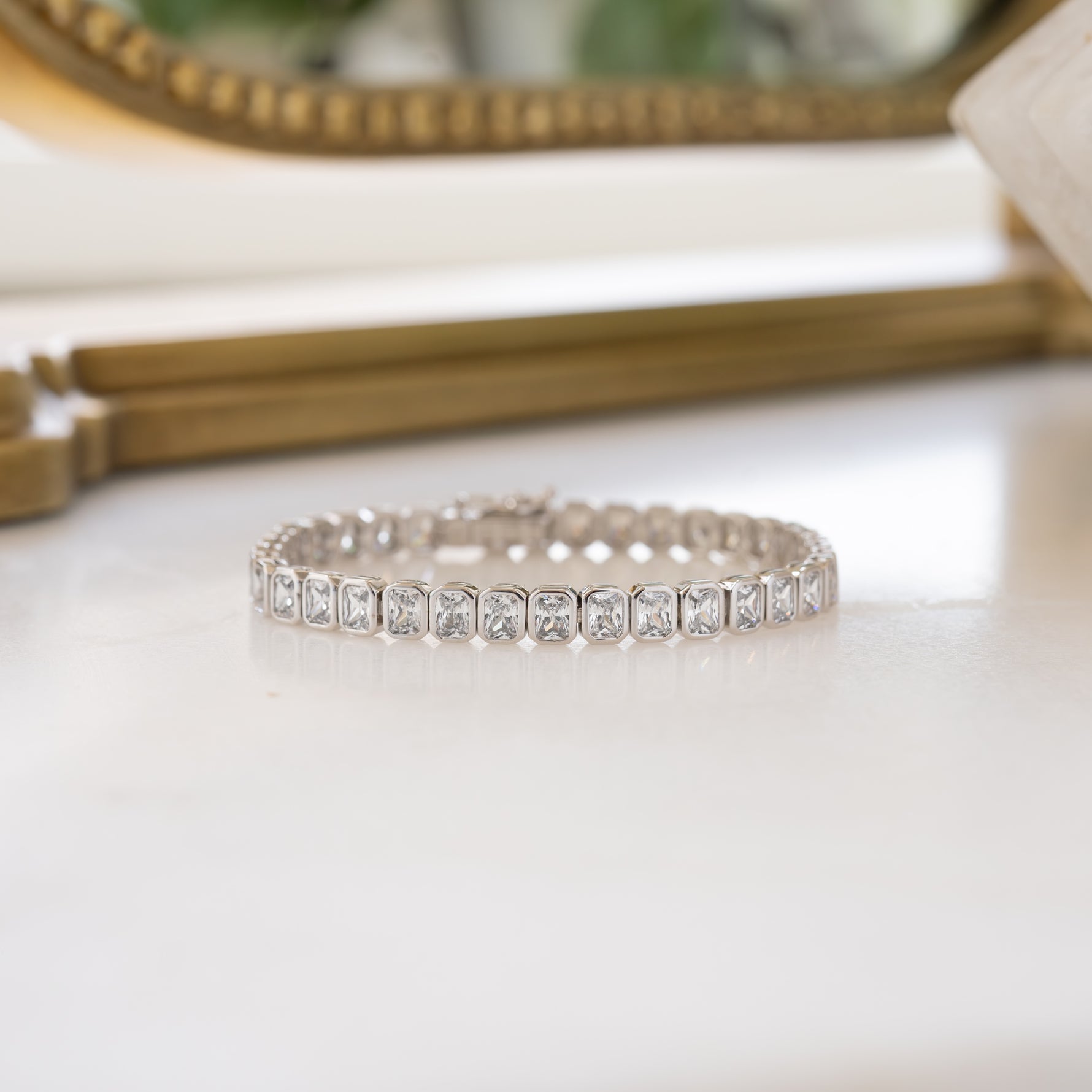 Silver Emerald-Cut Bezel Tennis Bracelet by Sami Jewels featuring sparkling gemstones and a secure clasp.