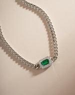 Close-up of Sami Jewels emerald-cut emerald bracelet with diamond halo setting in silver.