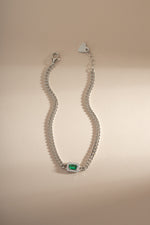 Emerald-cut emerald bracelet with diamond halo by Sami Jewels, featuring silver setting and intricate design.