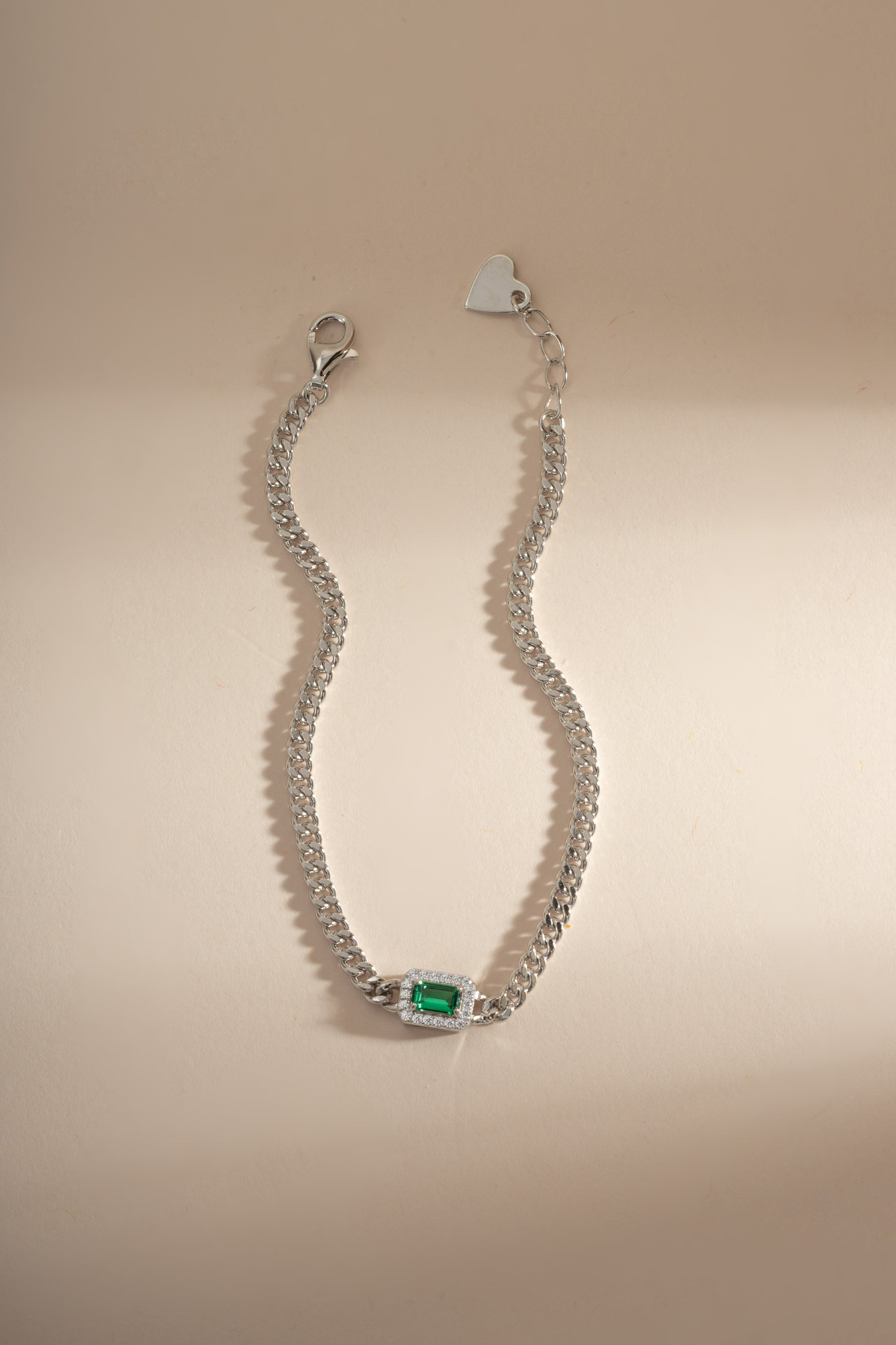 Emerald-cut emerald bracelet with diamond halo by Sami Jewels, featuring silver setting and intricate design.