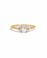 Elegant gold stacking ring with emerald-cut diamond by Sami Jewels, displayed on a white background.