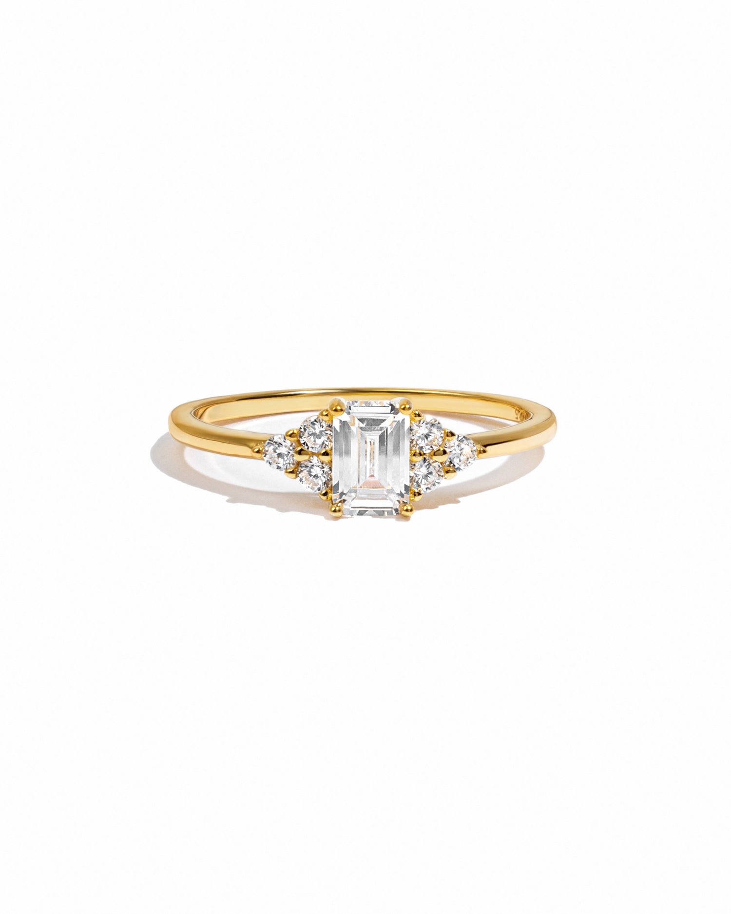 Elegant gold stacking ring with emerald-cut diamond by Sami Jewels, displayed on a white background.