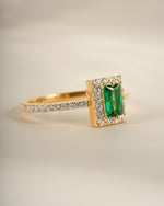 Sami Jewels emerald-cut emerald gemstone ring with gold band, showcasing a sparkling green center stone and elegant design.