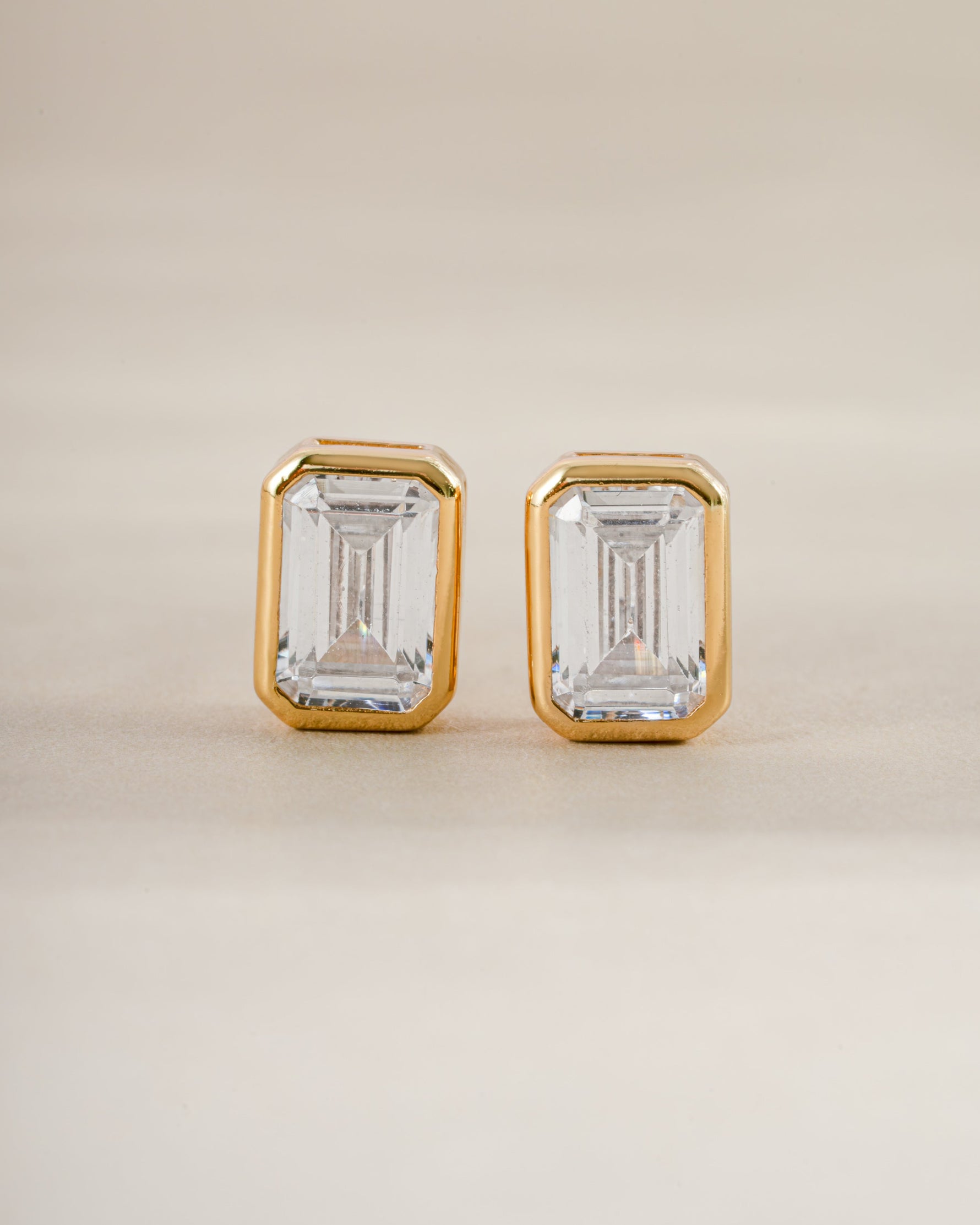 Gold emerald cut stud earrings by Sami Jewels shown from the front, highlighting their sleek rectangular gemstone design.
