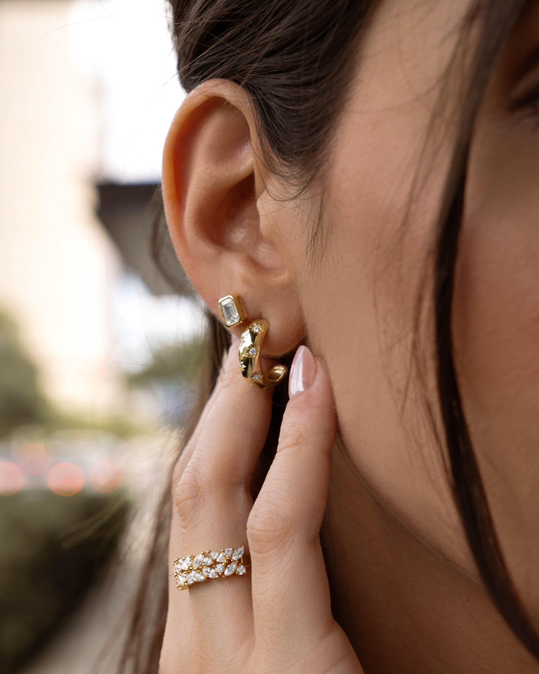 Gold emerald cut stud earrings by Sami Jewels, shown on a styled model with close-up of the elegant, geometric jewelry design.