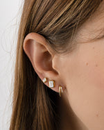 Gold emerald-cut stud earrings by Sami Jewels displayed on a styled model, showcasing their elegant and sparkling gemstone design.
