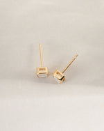 Gold Sami Jewels emerald cut stud earrings viewed from the top, showcasing their rectangular gemstone design.