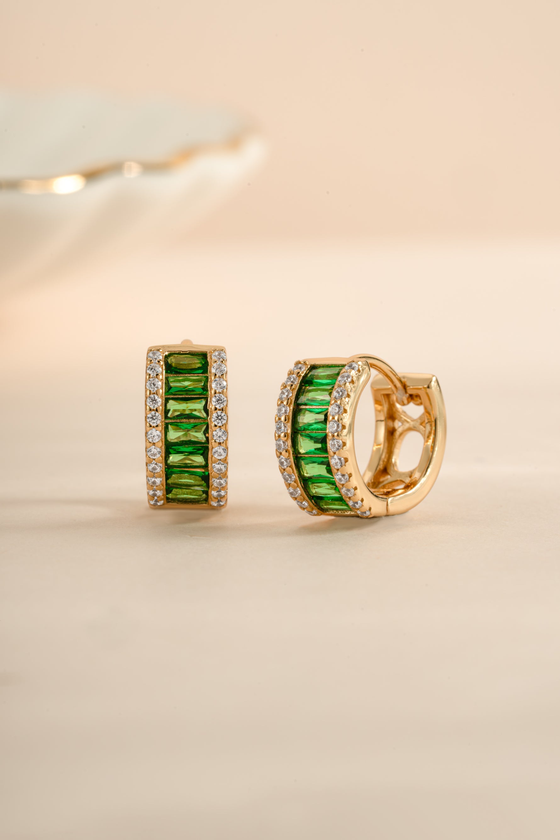 Sami Jewels emerald diamond baguette hoop earrings with gold setting, angled view showcasing elegant design and sparkling gemstones.