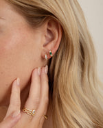 emerald three stone huggie hoop earring stacked in gold on model