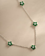 Close-up of SJ Faire Emerald Flower Necklace featuring a sterling silver chain and detailed emerald flower charm.